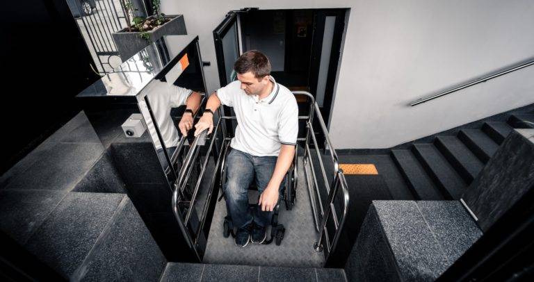 a man in a wheel chair using an accessible platform lift